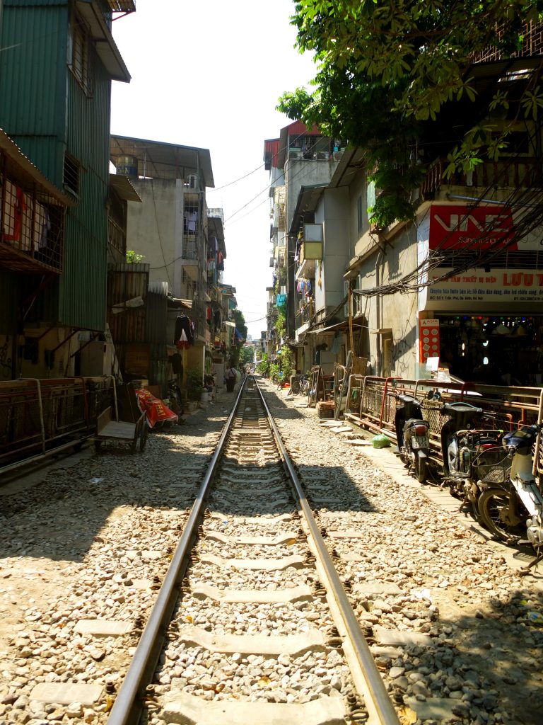 une voie de chemin de fer, droite dans une ville probablement en Inde