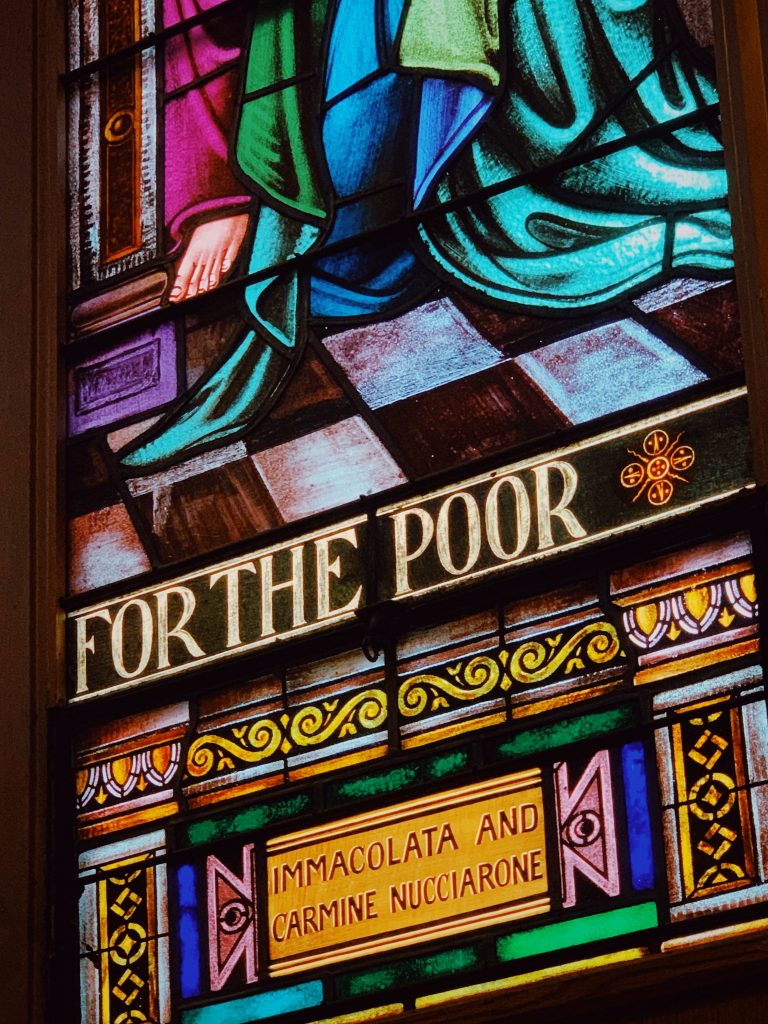 Une section de vitrail, avec l'inscription en anglais "For the poor" (pour le pauvre).