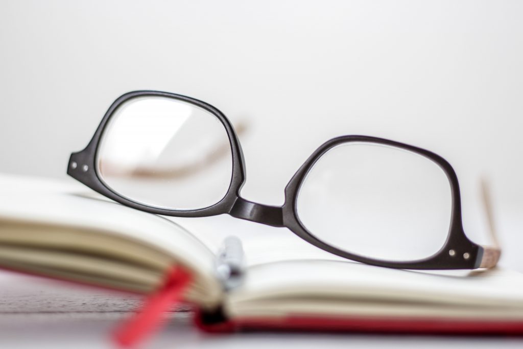 Une paire de lunettes posée sur un livre ouvert