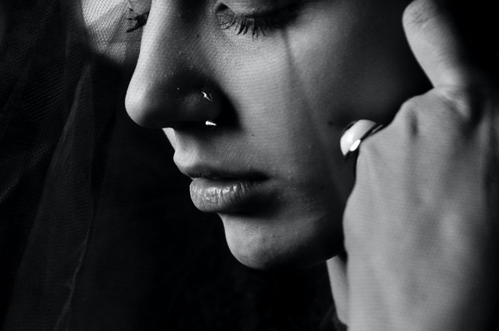 le visage d'une jeune femme, plein de tristesse, qui se demande peut-être "la souffrance, quel sens?"