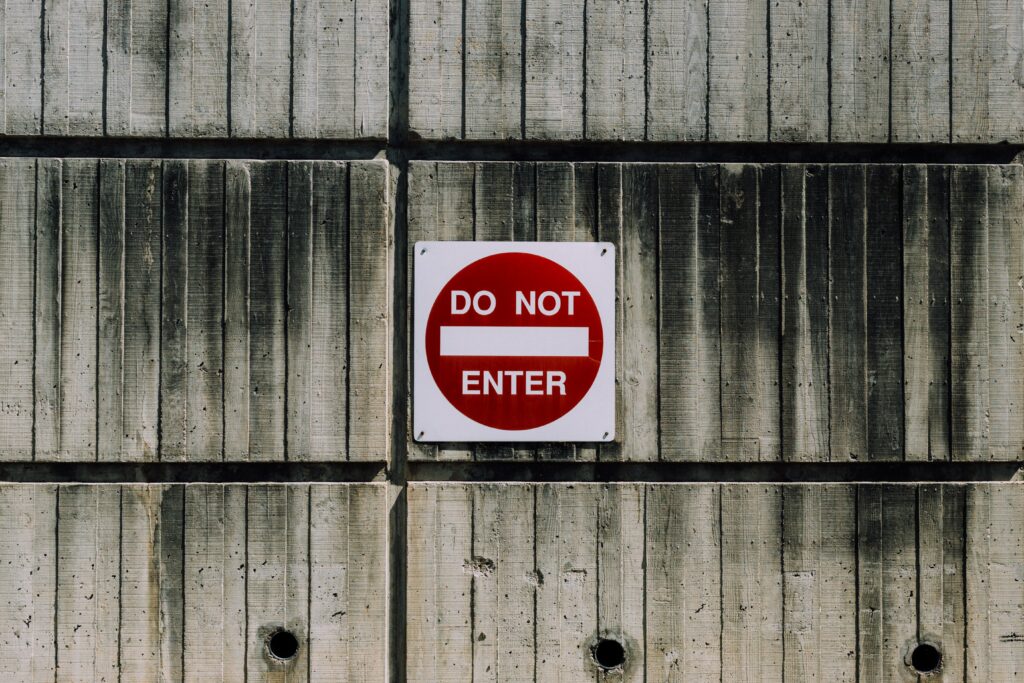 Photo d'un mur en béton avec un panneau d’interdiction d'entrer ("do not enter")