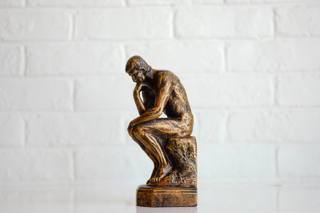 Statuette (en bronze?) illustrant le philosophe, assis la tête reposant sur sa main droite. 