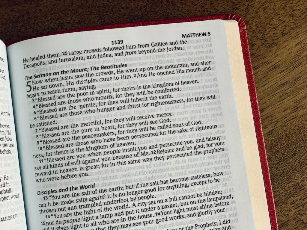Un Nouveau Testament en anglais, ouvert à la page des Béatitudes, pour se préparer à lire les Béatitudes sur YouTube